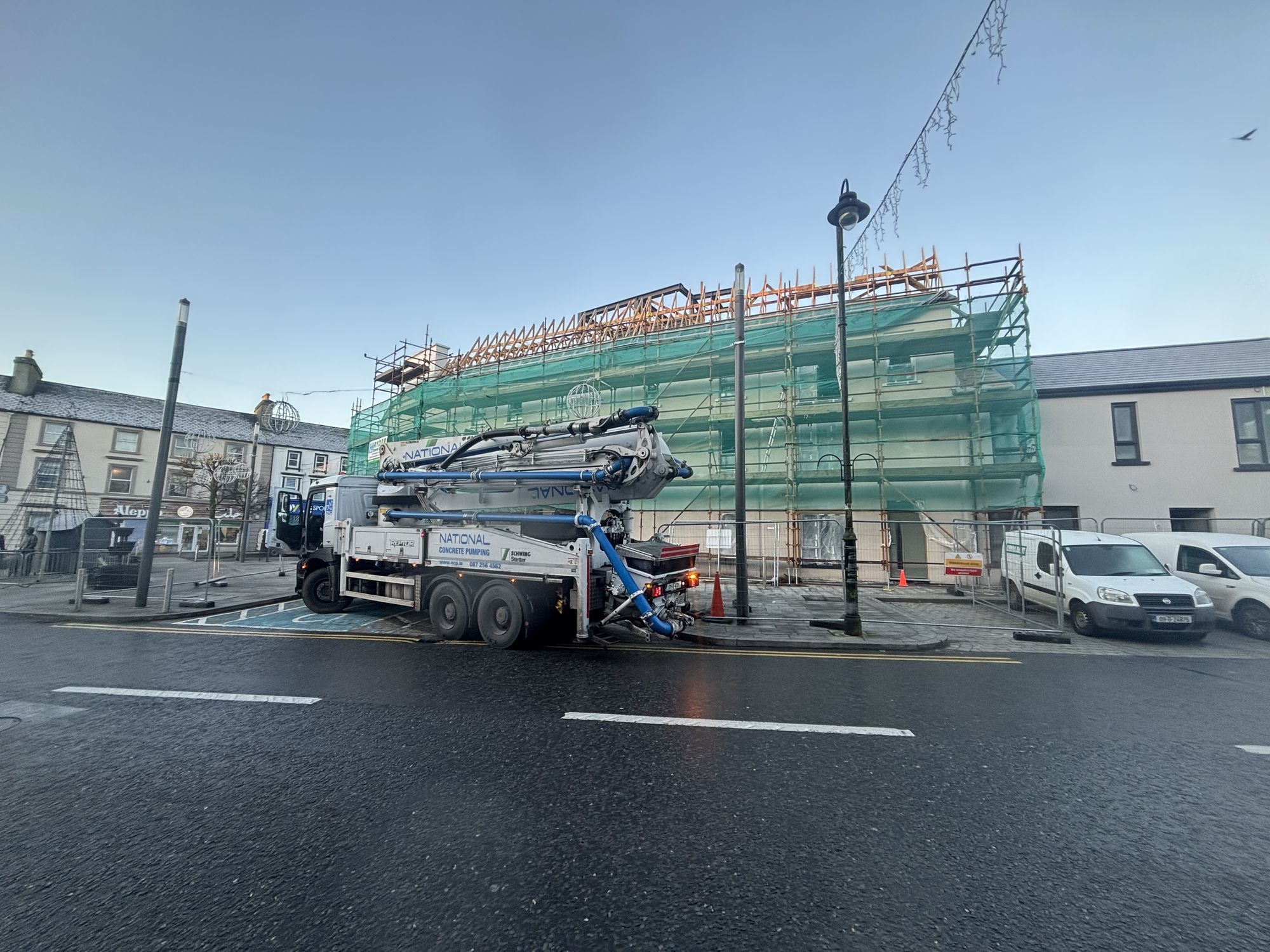 Concrete pump at a scaffolded town-centre building on a main street